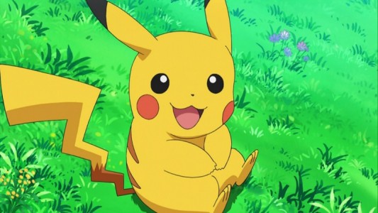 Pikachu de Pokémon est assis dans l'herbe et rit