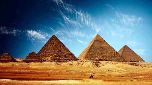 Pyramides en Egypte avec gens sur un chameau au premier plan