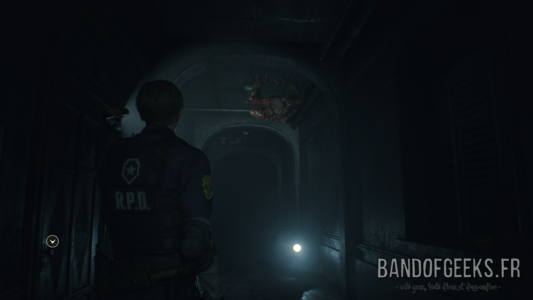 Resident Evil 2 Léon éclaire un Licker au plafond avec sa lampe torche
